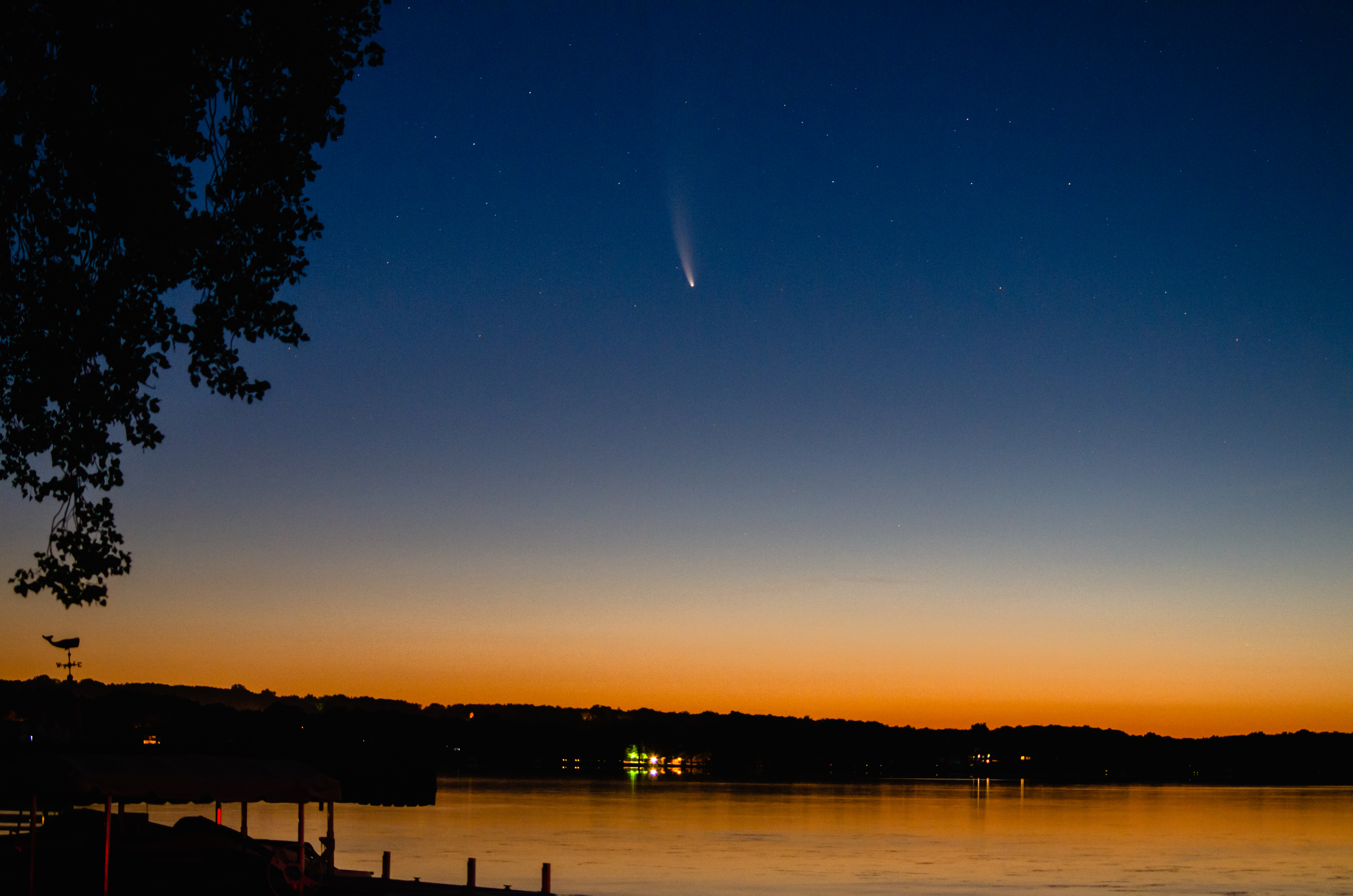 photo of comet over body of water during sunset
