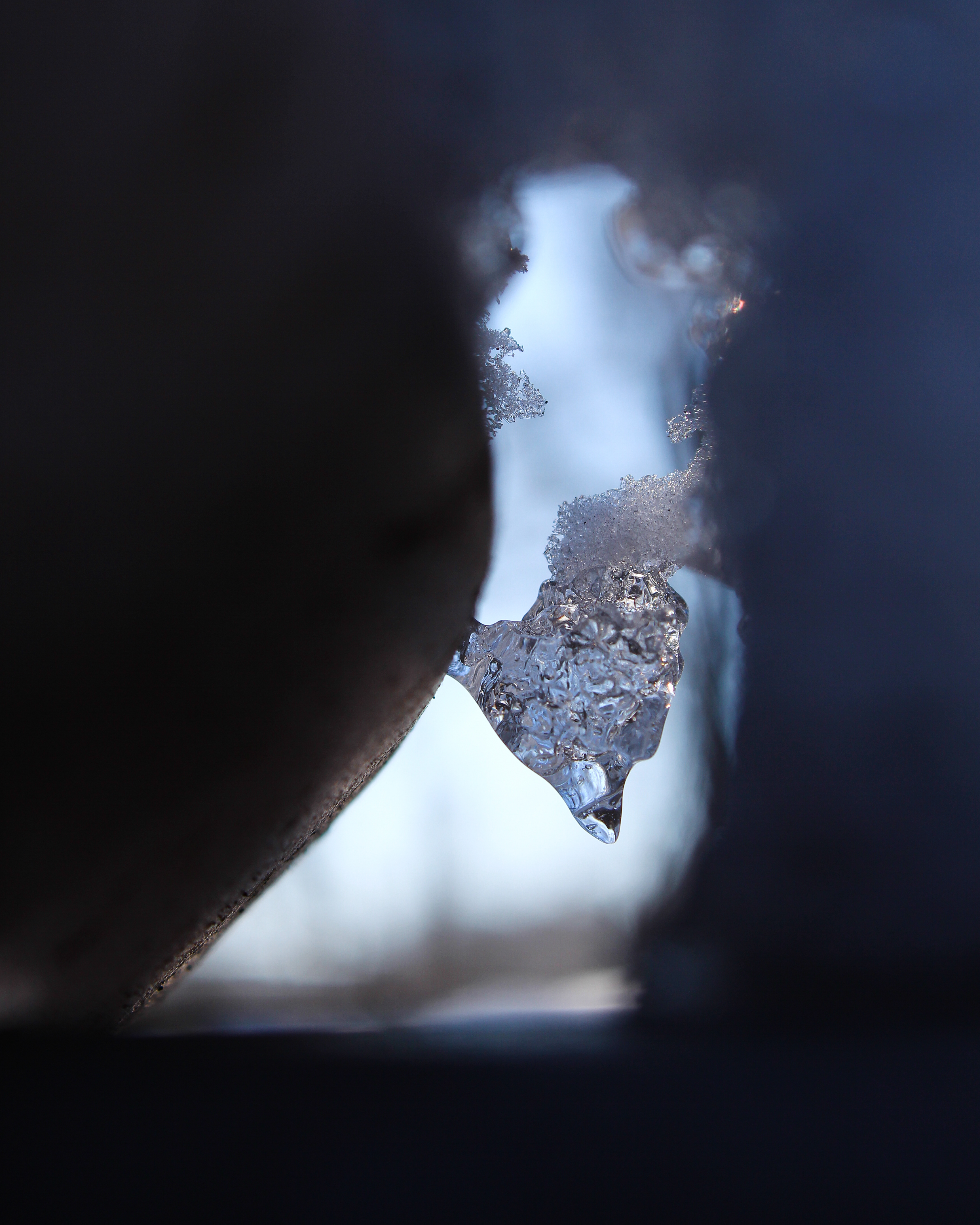 color photograph of snow crystals looking through dark hole