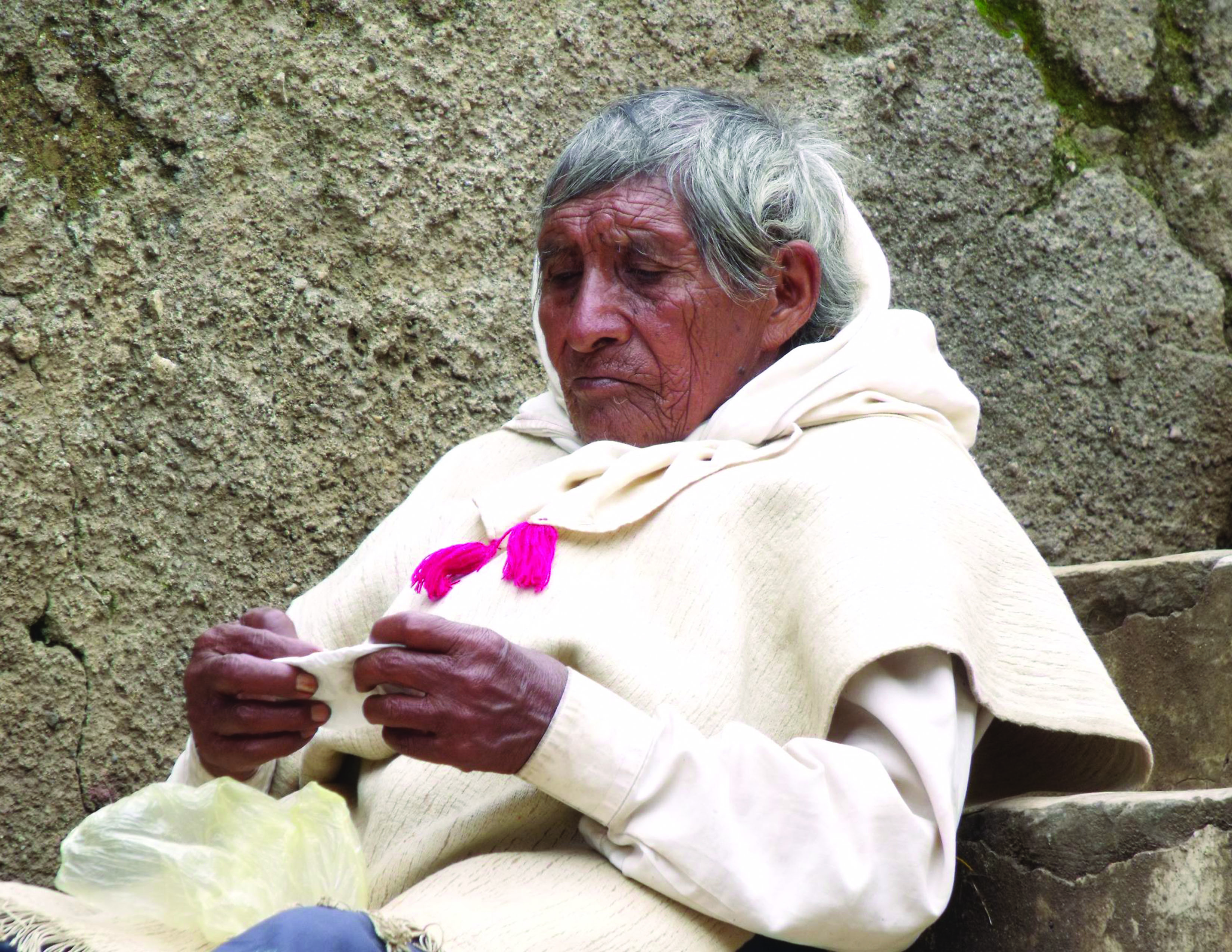 Color photo of a man from an autonomous mayan tribe in Chiapas, Mexico, sat outside a catholic church