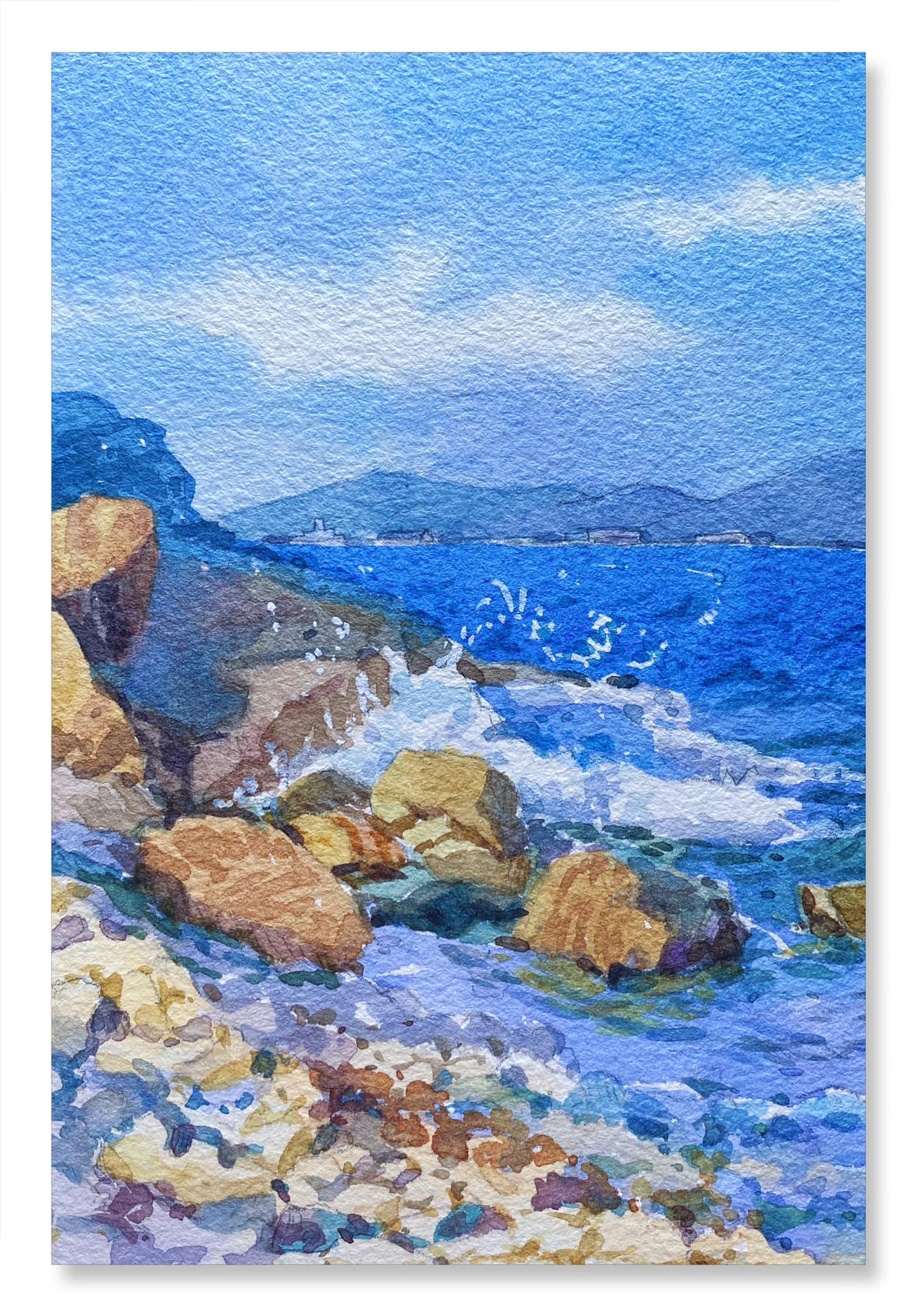 watercolor painting of waves crashing on rocky shore with blue sky above and mountainous horizon in background