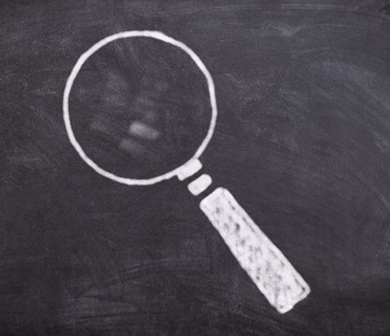 Drawing of a magnifying glass on a chalkboard