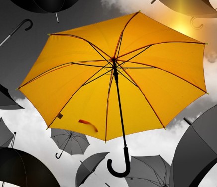 Photo of a yellow umbrella among grey umbrellas