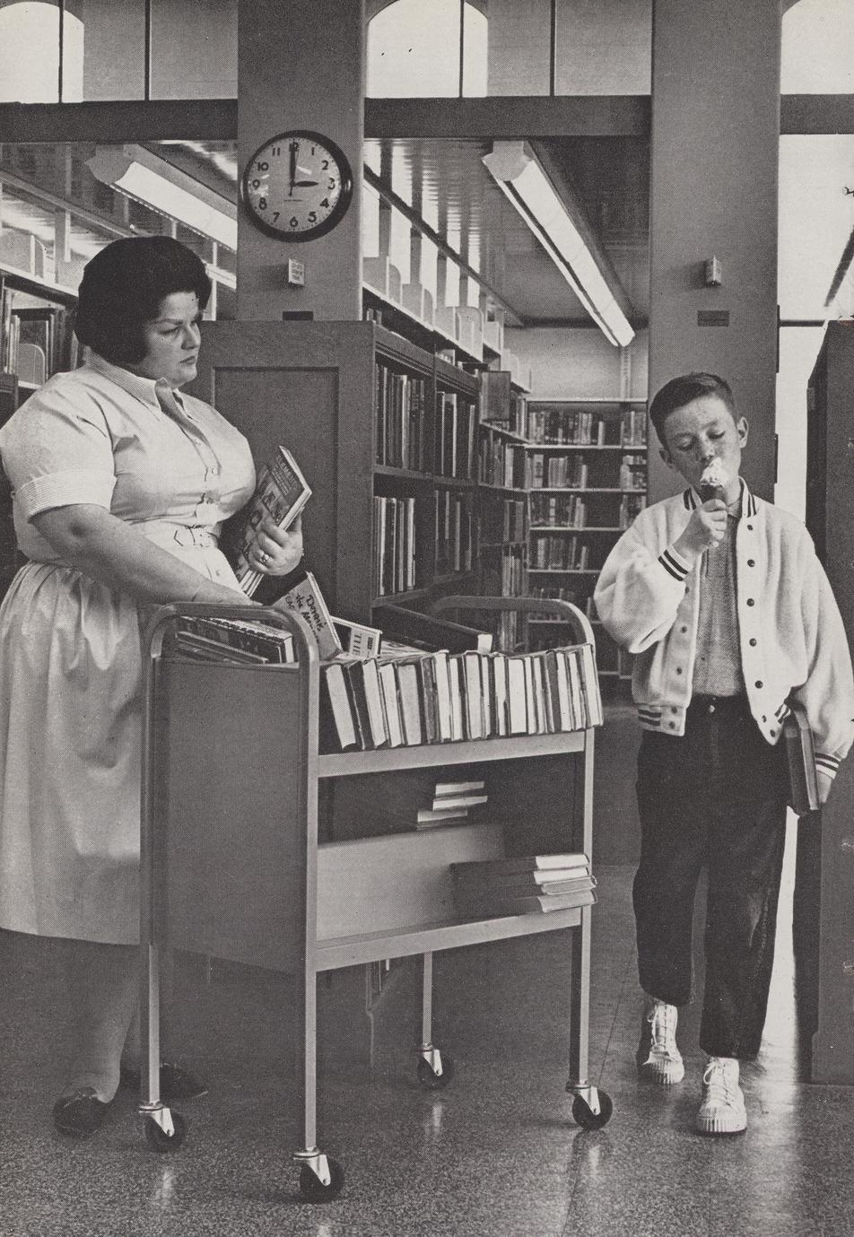 Nurse looks disapprovingly at boy eating ice cream in the library