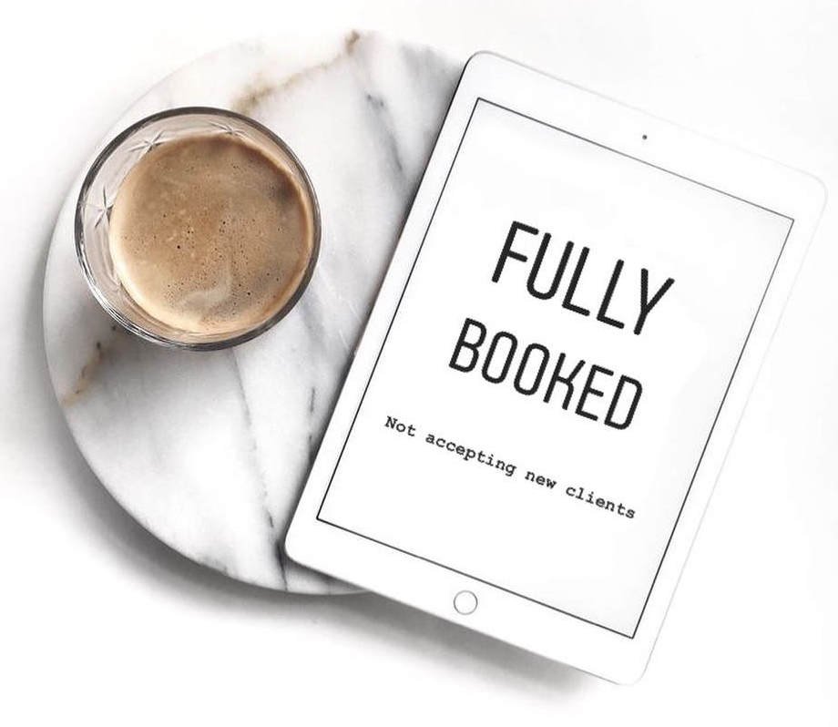 A coffee sits beside an ipad reading "Fully Booked"